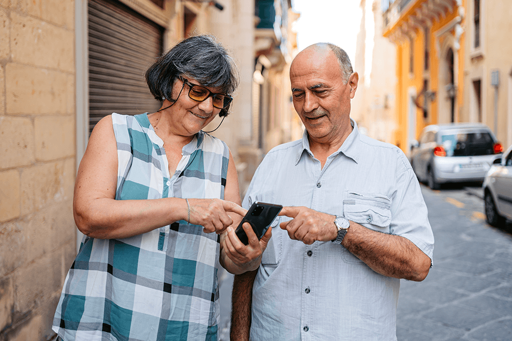 A senior couple playing the lottery on their phone in town 